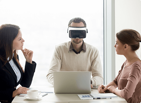 person wearing a virtual reality headset while others try to collaborate