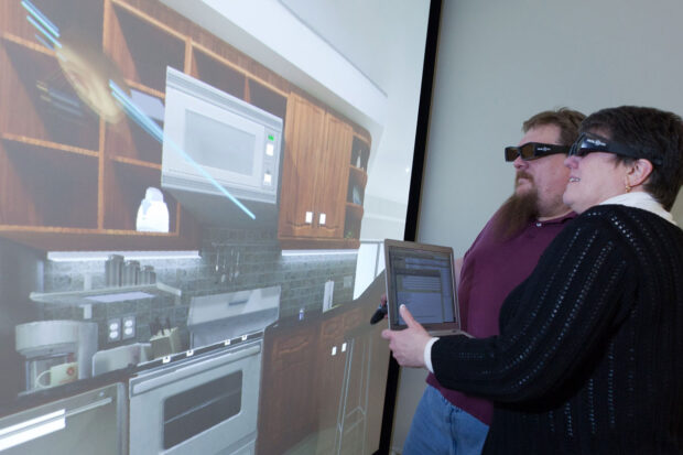 Two people looking at a kitchen design on the powerwall