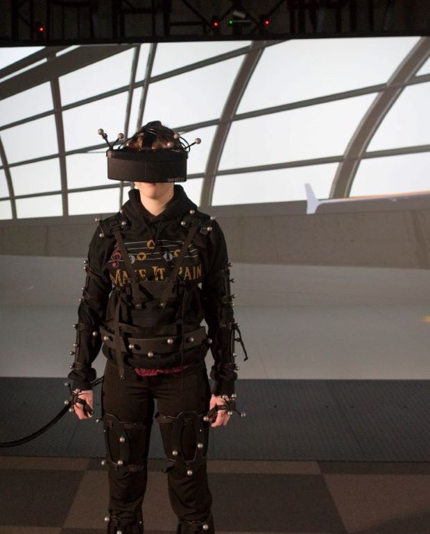 Virtual reality user with head mounted VR VIVE display and full body motion tracking suit